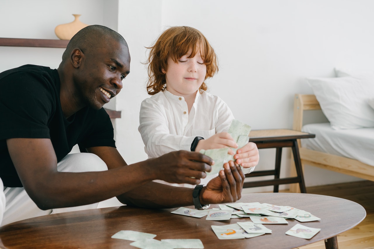 un enfant autiste jouant aux cartes avec son éducateur